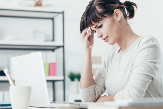 Woman with headache in the office