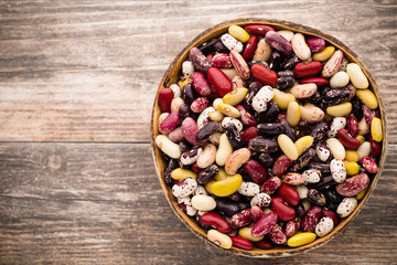 Beans  on the bowl and wooden background.