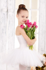 beautiful little ballerina with a bouquet of pink tulips, March 8