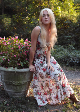 Pretty Young Woman in Floral Dress Outdoors With Flowers