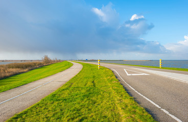 Road over a dike along a lake in winter
