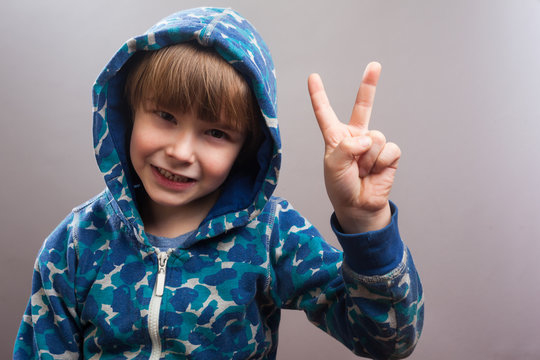 Junge zeigt Siegeszeichen mit zwei Fingern
