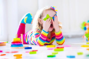 Little girl playing with wooden toys