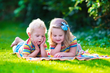Two kids reading in summer garden