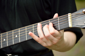 Fototapeta na wymiar Closeup of guitar neck with guitarist playing