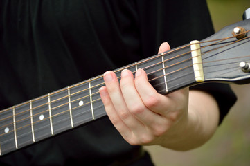 Fototapeta na wymiar Closeup of guitar neck with guitarist playing