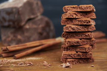 Porous chocolate and cinnamon on a wooden background