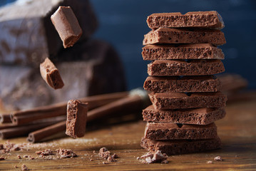 Porous chocolate and cinnamon on a wooden background
