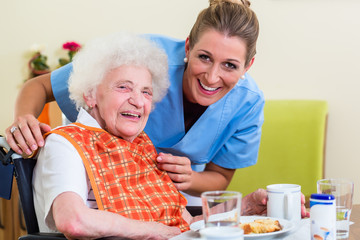 Pflegerin mit Seniorin beim Essen im Seniorenheim
