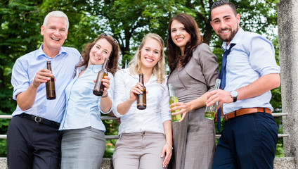 Büro Kollegen stoßen am Feierabend auf der Terrasse mit Bier an und feiern