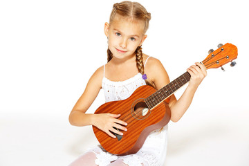 Beautiful little girl with a guitar 