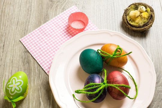 easter concept with colorful edible eggs over pink pastel plate