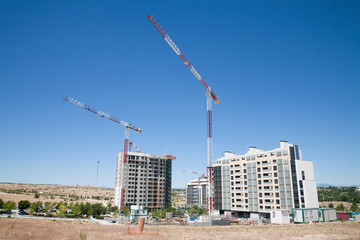 Fototapeta na wymiar two cranes in construction side