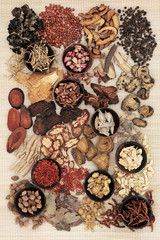 Chinese Herbal Medicine. Traditional chinese herbal medicine in wooden bowls and loose over bamboo background.