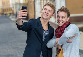 Cheerful day of twin brothers. Two stylish and handsome adult tw