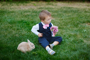 little boy in suit with a bouquet and a rabbit