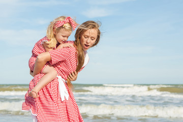 Fototapeta na wymiar Mother and her daughter having fun on the beach