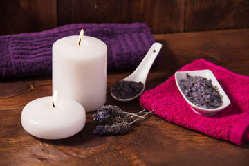 Fototapeta na wymiar Spa candle and lavender flower bath salts massage oil and pink towel