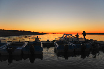 Fototapeta na wymiar Fishermen at sunset on the Volga river in the spring
