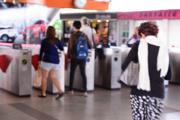 Blurred peoples using automatic ticket machine at train station.