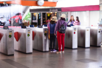 Blurred peoples using automatic ticket machine at train station.