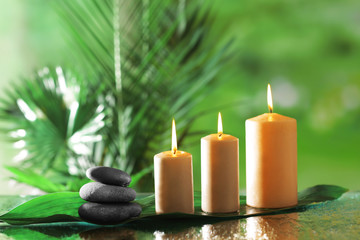 Spa composition of candles, stones and bamboo on blurred background