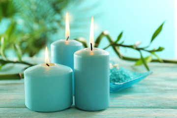Blue candles with spa salt and bamboo on table