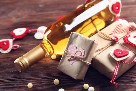 White wine bottle and gift box on wooden background