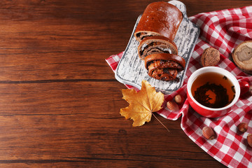 Fototapeta na wymiar Cup of tea with autumn decor on wooden table.