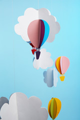 Paper clouds and airship on blue background