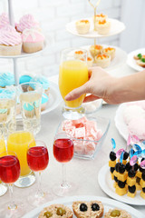 Woman holding glass of juice on buffet background