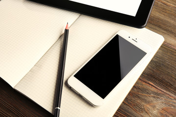 Mobile phone, notebook, pen and tablet on the table, close-up