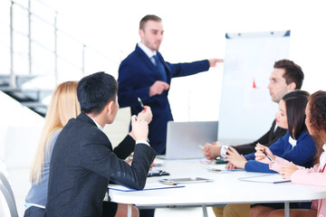 Young businessman making a presentation on a board in the office