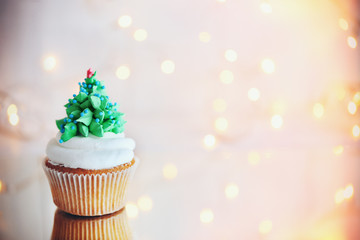 Christmas cupcake with lights on background