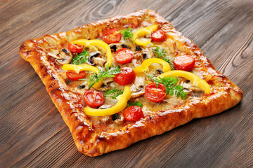 Freshly homemade pizza on wooden background