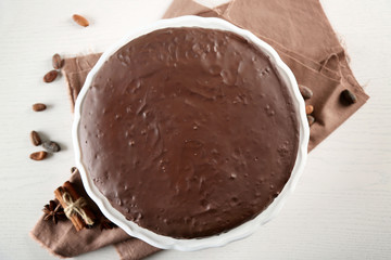 Tasty chocolate frosting cake on light table