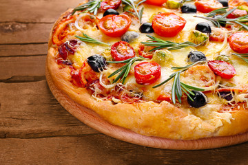 Delicious fresh pizza on wooden background