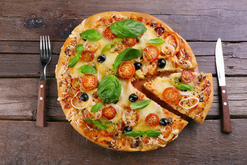 Delicious fresh pizza on wooden table, top view