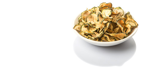 Dried zucchini or courgette in white bowl over white background
