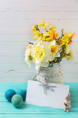 Spring yellow daffodils flowers in vase,  Easter eggs  and empty