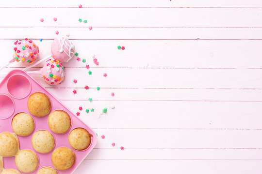 Making cake pops on light pink  wooden background.