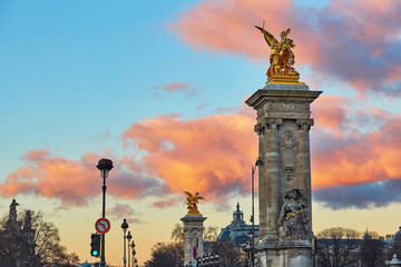 Fototapeta na wymiar Dramatic sunset over the columns of Pont Alexandre III in Paris