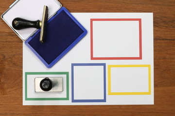 Rubber stamp with ink on white paper placed on a wooden floor.