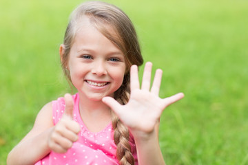 Smiling girl showing thumb up