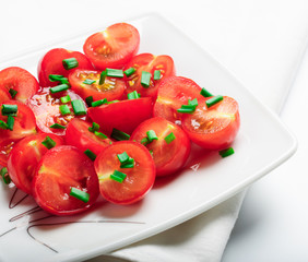 Cherry tomatoes decorated with green onions.