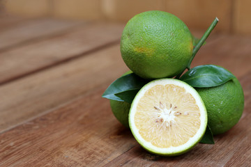 Fresh green orange (a kind of orange) isolated on wood background