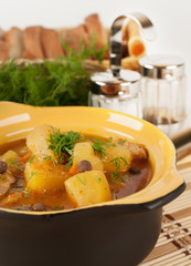 Stewed potatoes in a ceramic pot.