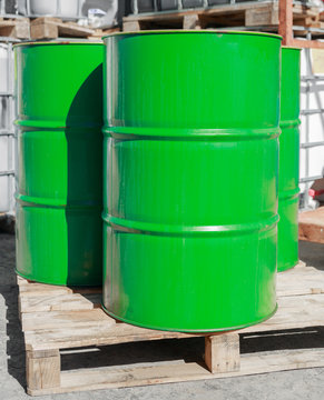 Green barrels on wooden pallets