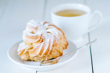Choux pastry whith a cup of tea on the white wooden table