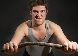 Excited  man broke the stick into two pieces. Studio on black.
